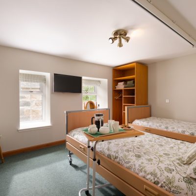 Bedroom with Ceiling Track and Electric height-adjustable bed and TV on the wall