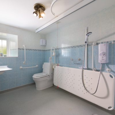 Wetroom with shower stretcher, overhead hoist, height-adjustable wash basin and closomat toilet